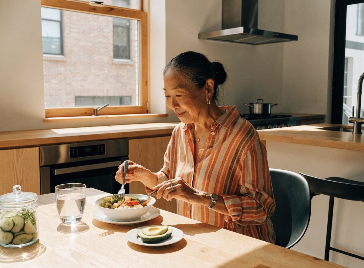 An older woman eating a healthy, protein-rich meal in a bright home kitchen